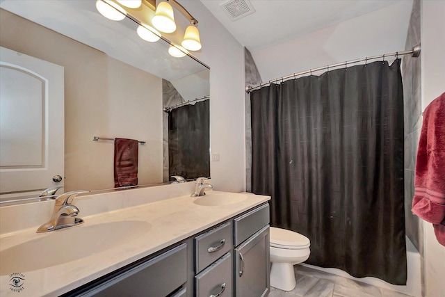 bathroom with visible vents, a sink, toilet, and double vanity