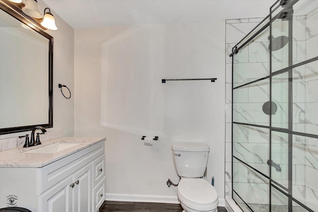 full bathroom featuring baseboards, a shower stall, toilet, and vanity