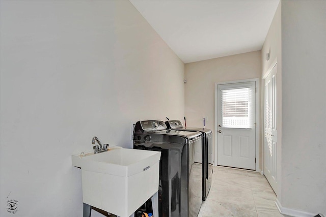 clothes washing area with a sink, laundry area, and washing machine and clothes dryer