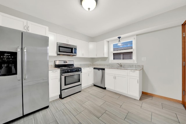 kitchen featuring sink, light stone countertops, white cabinetry, and stainless steel appliances