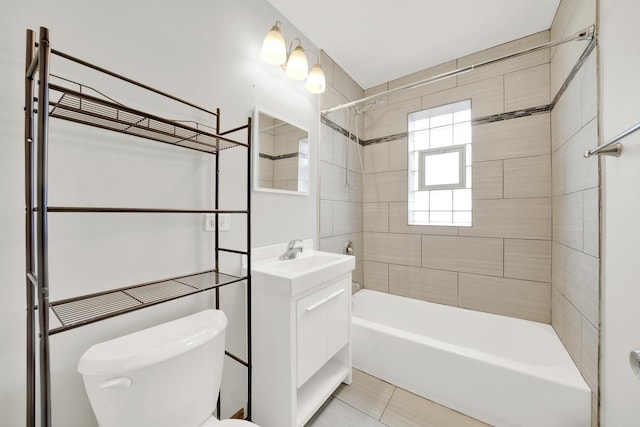 full bathroom with tile patterned floors, tiled shower / bath, vanity, and toilet