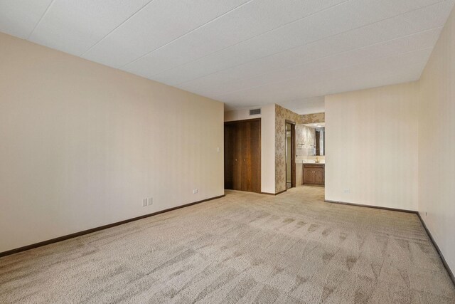 corridor with a paneled ceiling and light wood-type flooring