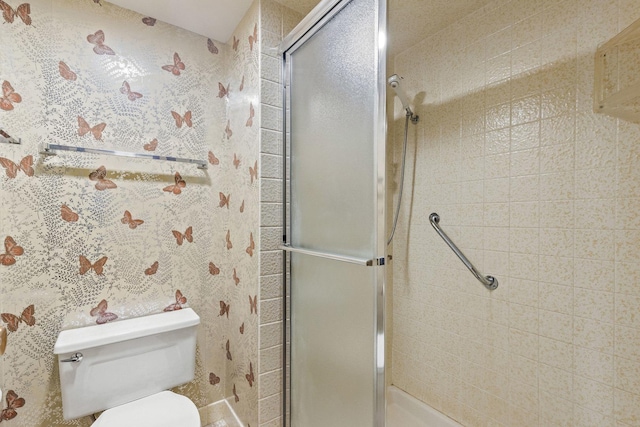 bathroom featuring toilet and a shower with door