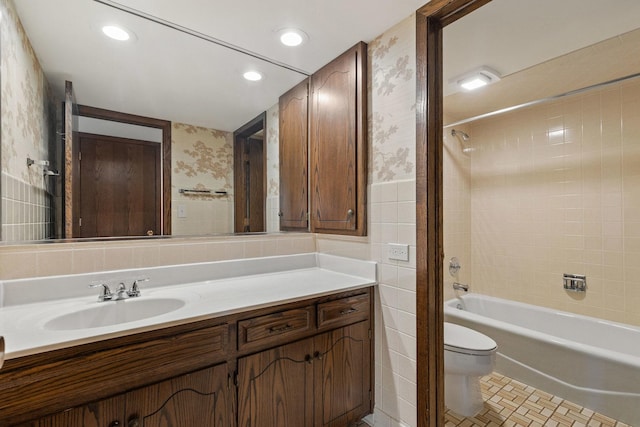 full bathroom featuring tile patterned flooring, toilet, vanity, tile walls, and tiled shower / bath