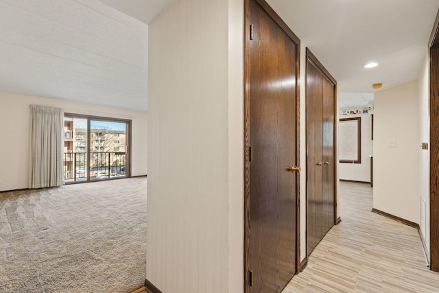 hallway featuring light colored carpet