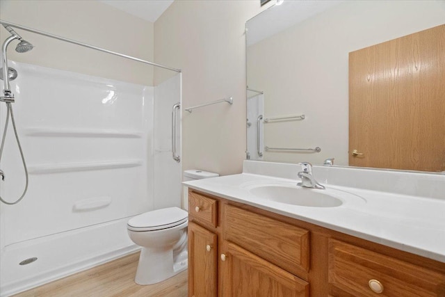 bathroom with vanity, hardwood / wood-style flooring, toilet, and walk in shower