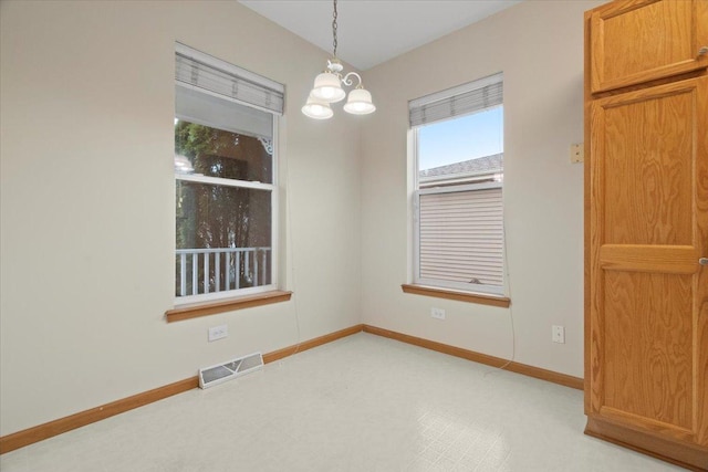 spare room featuring an inviting chandelier