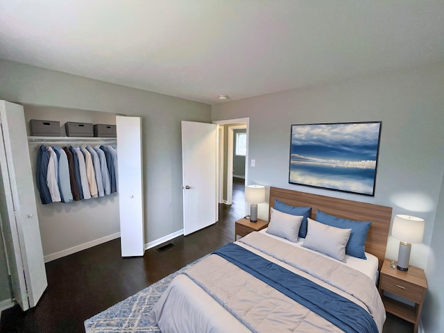 bedroom with dark hardwood / wood-style flooring and a closet