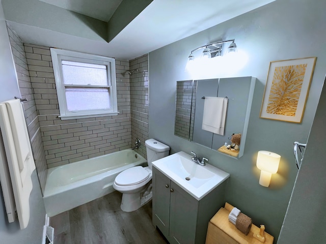 full bathroom with vanity, tiled shower / bath combo, hardwood / wood-style flooring, and toilet