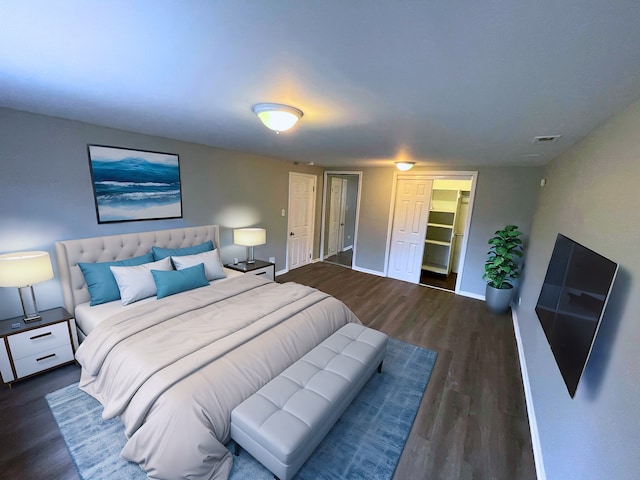 bedroom with dark hardwood / wood-style floors and a closet