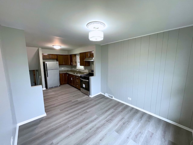 kitchen with sink, light hardwood / wood-style flooring, stainless steel range oven, and white refrigerator