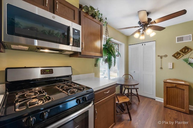 kitchen featuring appliances with stainless steel finishes, ceiling fan, and dark wood-type flooring