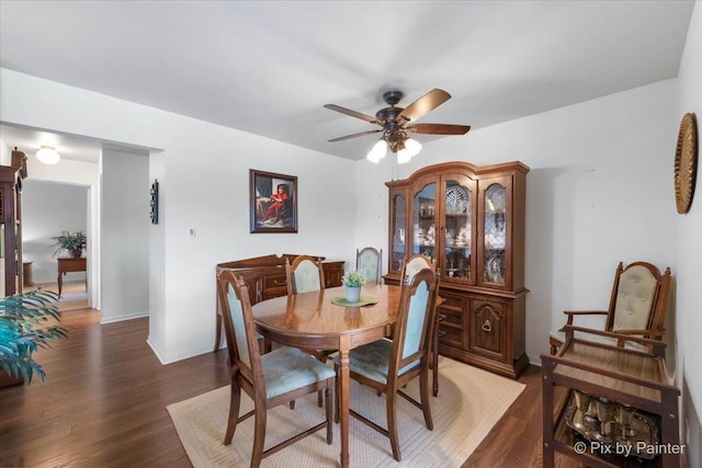 dining area featuring ceiling fan and dark wood-type flooring