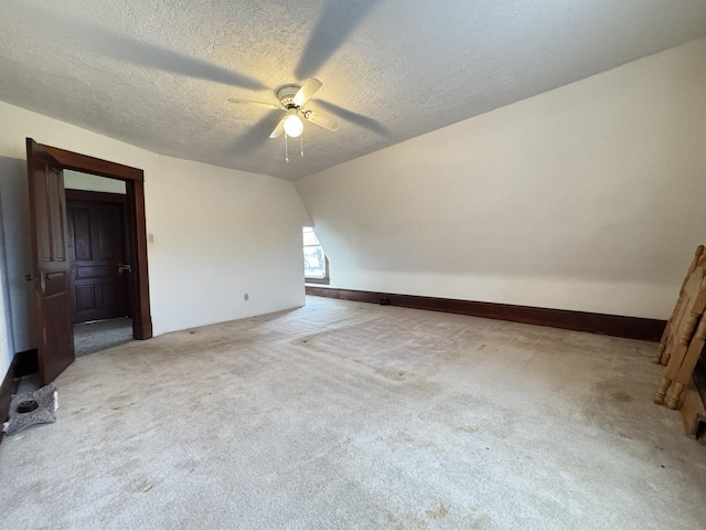 unfurnished room with ceiling fan, carpet floors, a textured ceiling, and vaulted ceiling