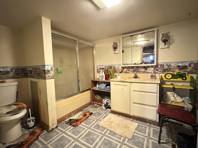 full bathroom featuring combined bath / shower with glass door, toilet, and vanity