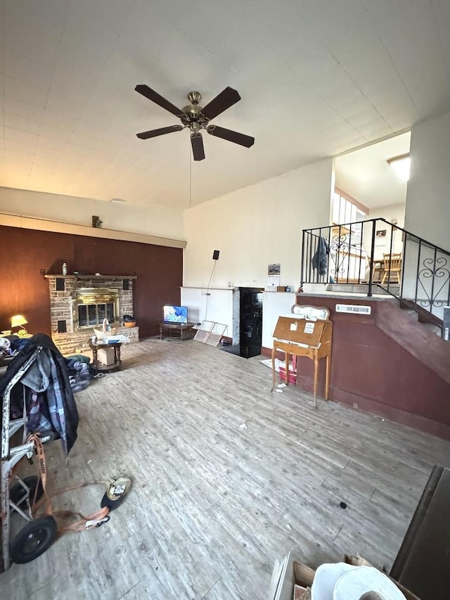 living room with ceiling fan, a fireplace, and hardwood / wood-style floors