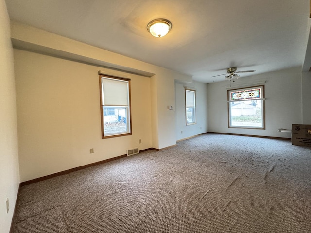 carpeted spare room featuring ceiling fan