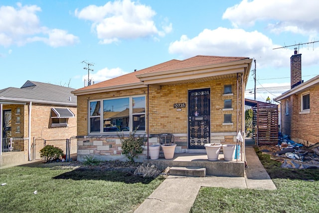 bungalow-style house featuring a front lawn and fence