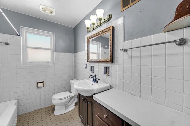 bathroom with visible vents, toilet, a sink, shower / tub combination, and tile walls