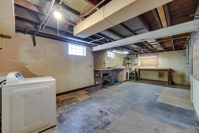 basement featuring electric panel, a workshop area, and washer / clothes dryer