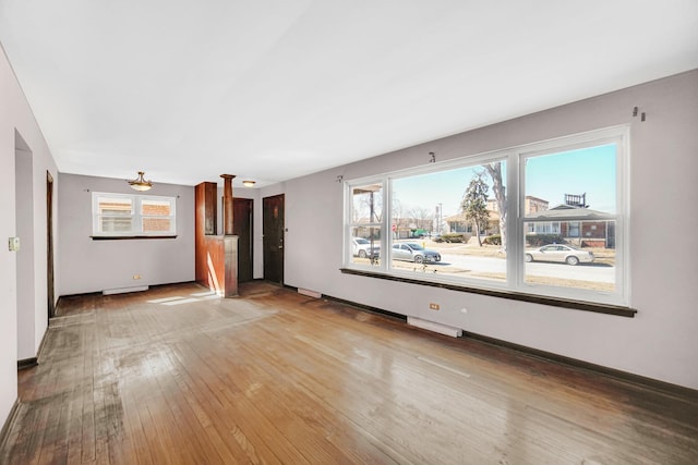 spare room with baseboards and hardwood / wood-style flooring