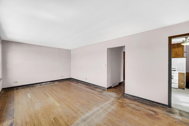 empty room featuring baseboards and light wood finished floors