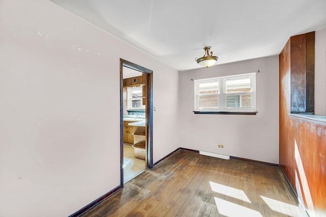 unfurnished room with baseboards, wood-type flooring, and visible vents