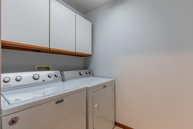 washroom featuring cabinets and washing machine and clothes dryer