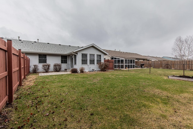 back of property with a sunroom, a yard, and a patio