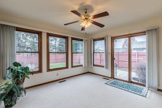 unfurnished sunroom with ceiling fan