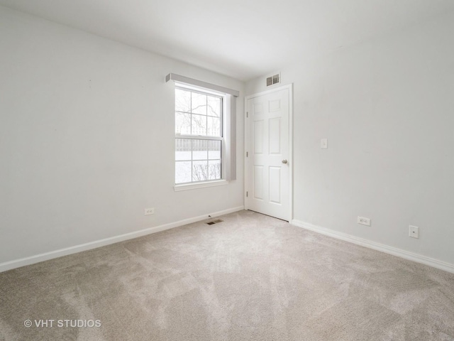 spare room featuring light colored carpet