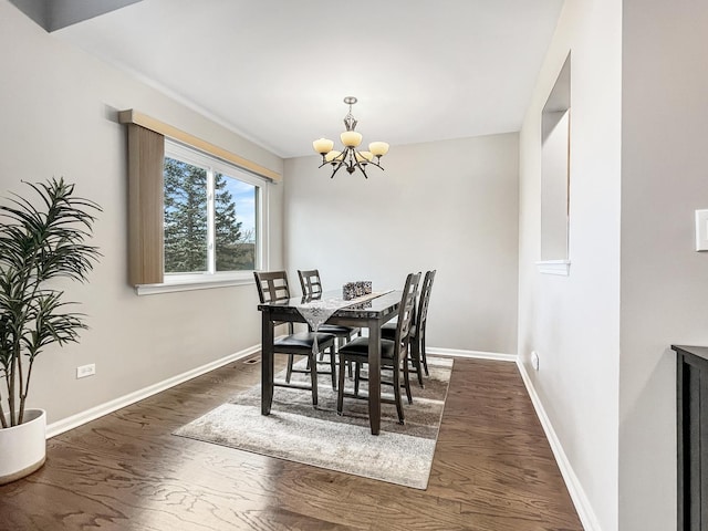 dining space featuring dark hardwood / wood-style floors and an inviting chandelier