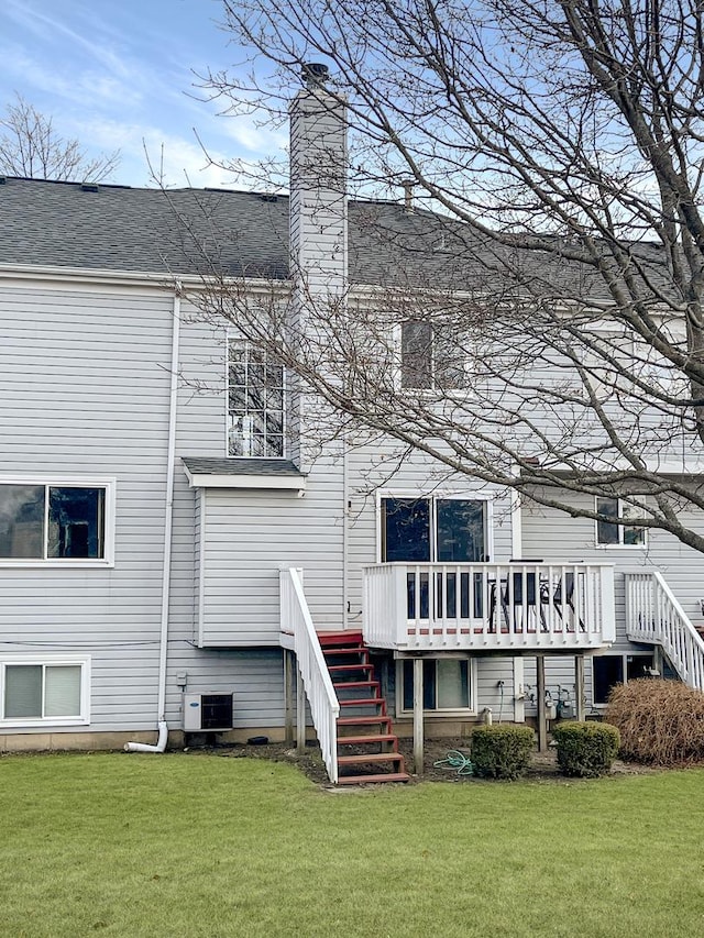 rear view of house featuring a lawn, a wooden deck, and central AC unit