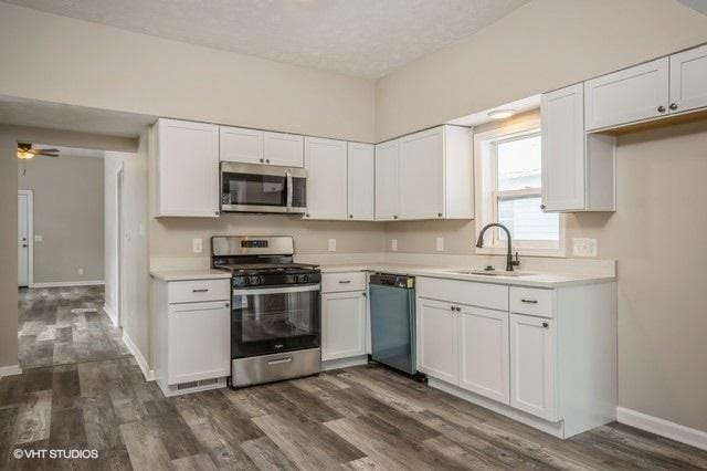 kitchen featuring white cabinets, dark hardwood / wood-style flooring, stainless steel appliances, and sink