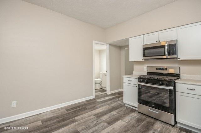 kitchen featuring white cabinets, dark hardwood / wood-style floors, and stainless steel appliances