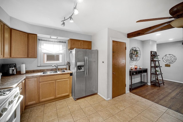 kitchen featuring ceiling fan, sink, stainless steel fridge, light tile patterned flooring, and white gas range oven