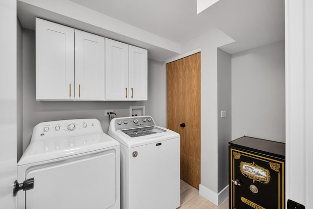 laundry room with separate washer and dryer and cabinets