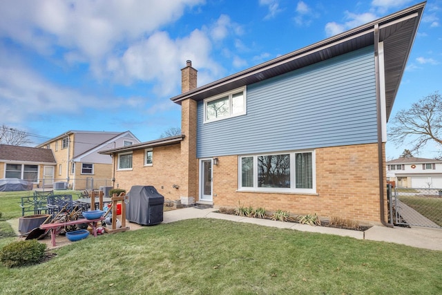 rear view of property featuring a yard and central AC unit