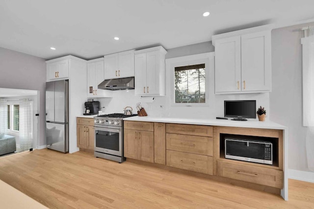 kitchen with white cabinetry, plenty of natural light, light hardwood / wood-style flooring, and appliances with stainless steel finishes