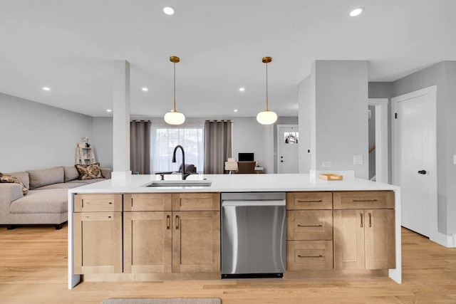 kitchen with stainless steel dishwasher, pendant lighting, sink, and light brown cabinetry