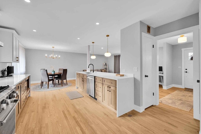 kitchen with sink, stainless steel appliances, light hardwood / wood-style flooring, a chandelier, and decorative light fixtures