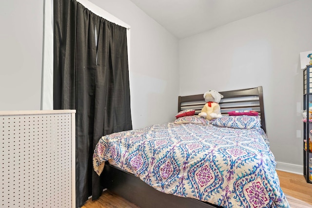 bedroom with wood finished floors and baseboards