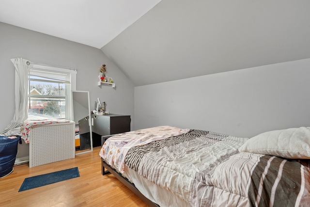 bedroom featuring vaulted ceiling and light wood-style flooring