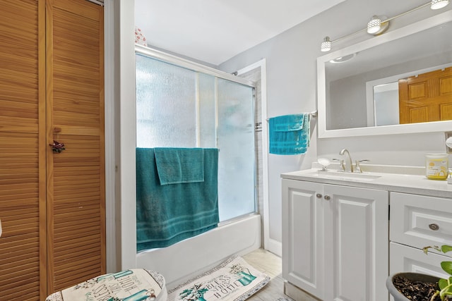 bathroom with combined bath / shower with glass door and vanity