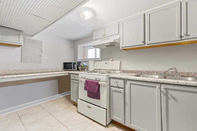 kitchen featuring white gas range oven, stainless steel microwave, light countertops, under cabinet range hood, and a sink