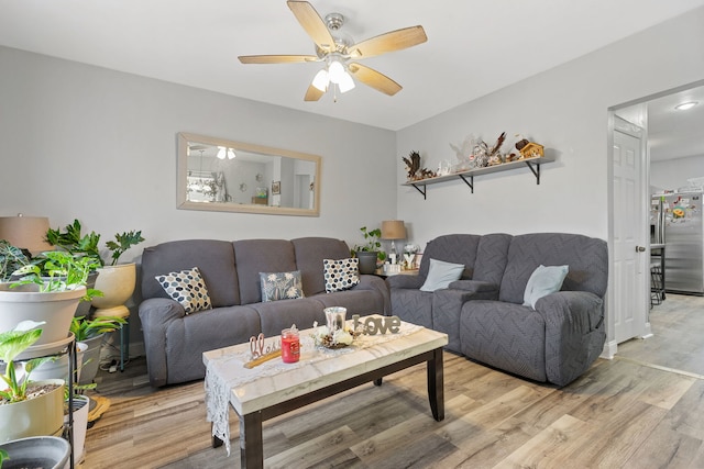 living area with a ceiling fan and light wood-type flooring