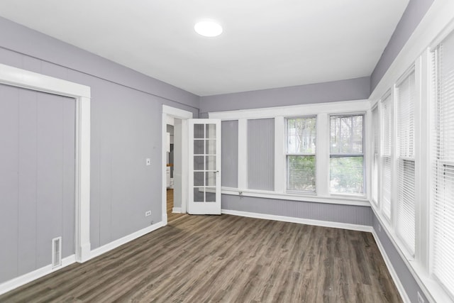 unfurnished bedroom featuring baseboards, a closet, wood finished floors, and visible vents