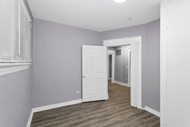 unfurnished bedroom featuring baseboards, wood finished floors, and visible vents
