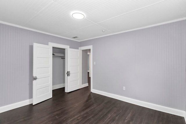 unfurnished bedroom featuring crown molding, baseboards, wood finished floors, and visible vents