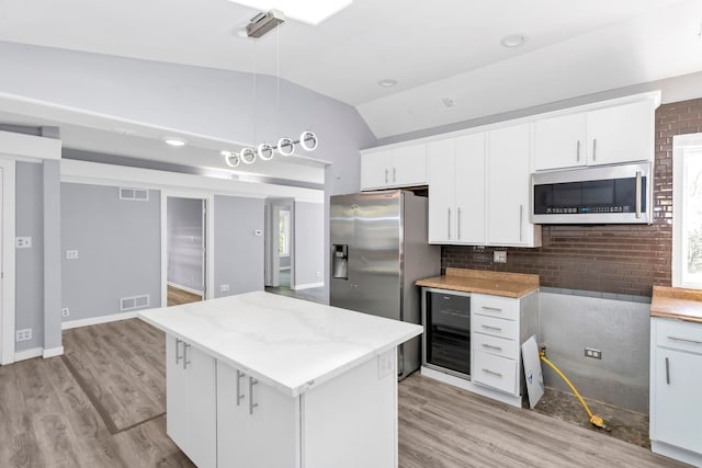 6N772 Tuscola Ave, Saint Charles, IL 60174 - kitchen featuring appliances with stainless steel finishes, wine cooler, light wood-style flooring, lofted ceiling, and a kitchen island